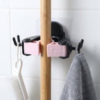 Wall mounted clip holder for mop and broom in use