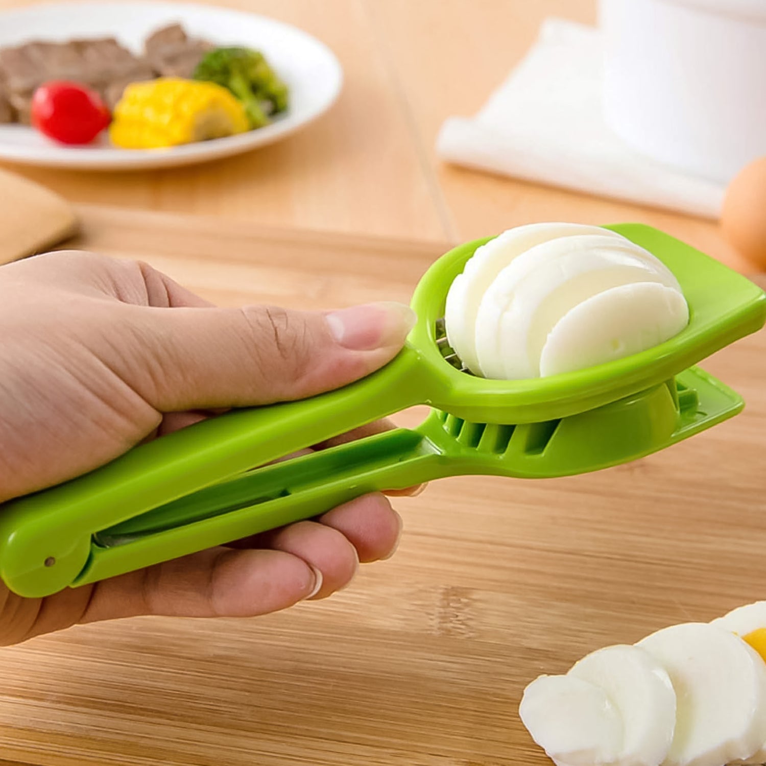 Hand holding the Multipurpose Slicer, creating uniform slices of fresh strawberries.
