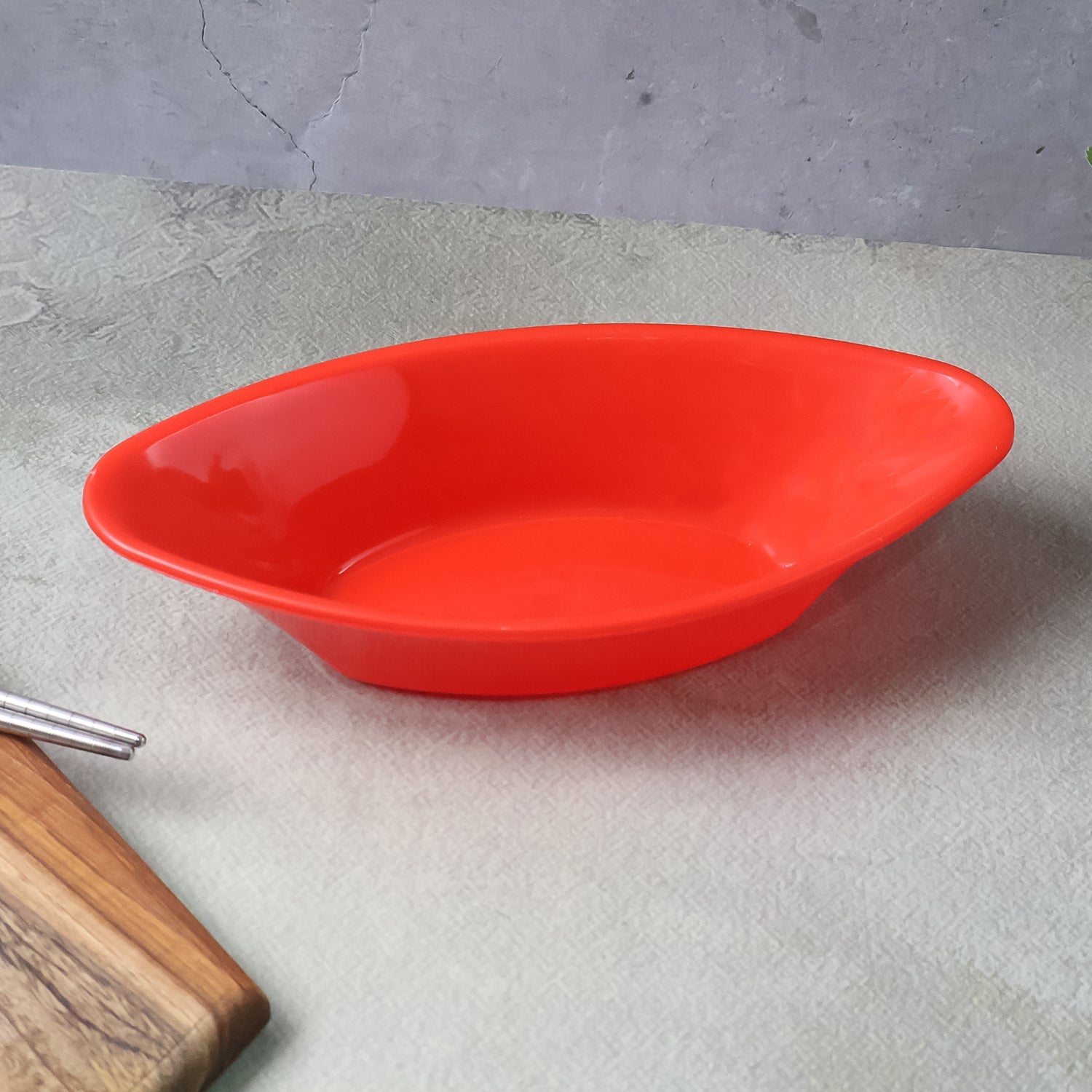 Angle shot of glossy red oval plastic Marin serving bowl