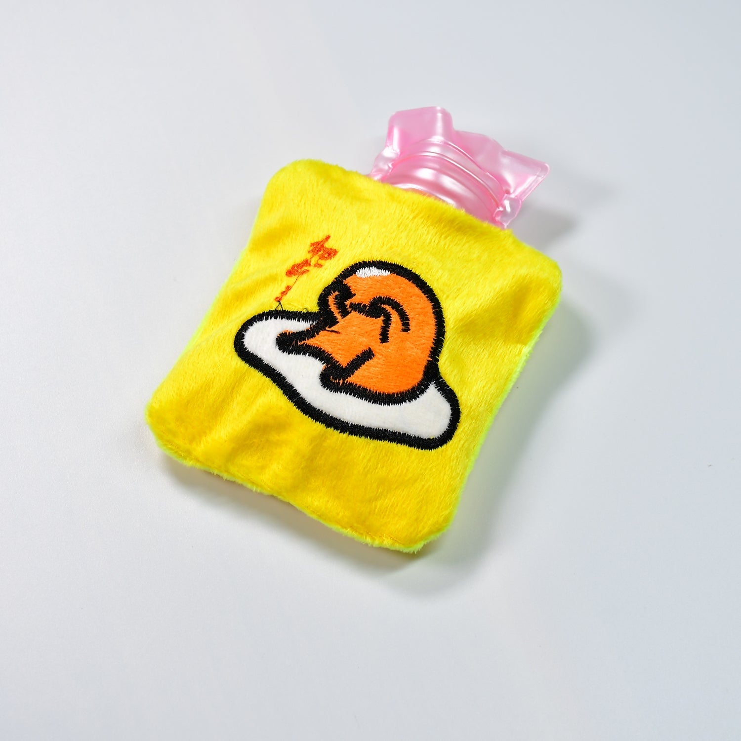 Bright yellow duck head hot water bag with a soft fabric cover for comfort.