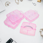 Plastic organizer box open with various craft supplies and jewelry items.
