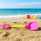 Kids beach sand shovel toy next to colorful sand bucket