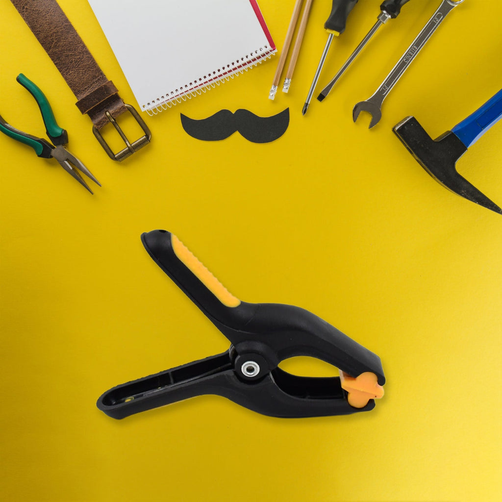 Detailed view of the ergonomic handle and yellow tip of a spring clamp.