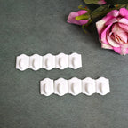 Set of 10 white plastic adhesive wall hooks for drill-free hanging.