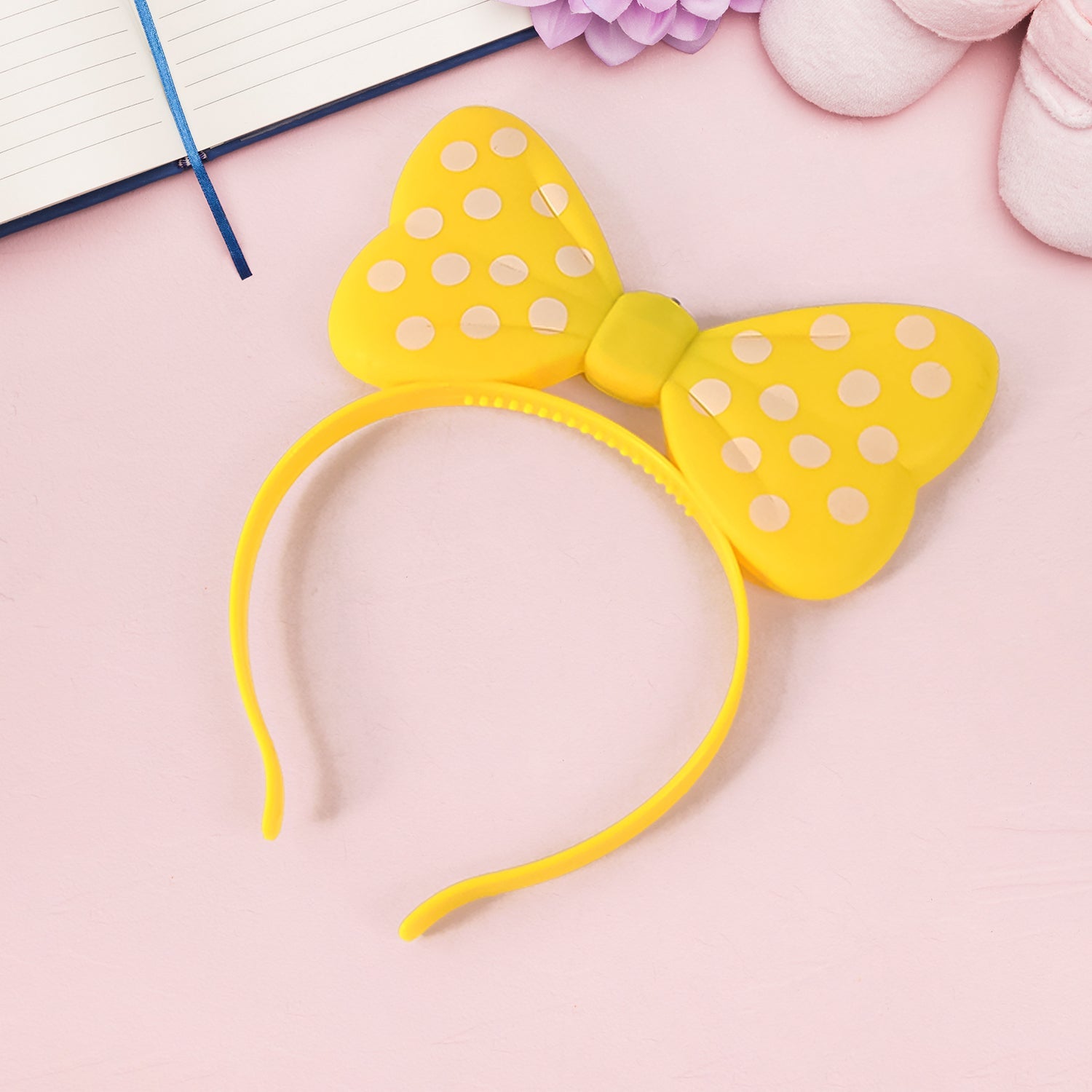 LED light-up bow hairband laid flat highlighting battery case