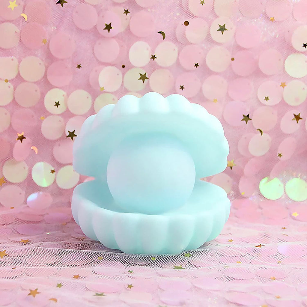 A hand holding the compact Pearl Shell Night Lamp, demonstrating its portable size.