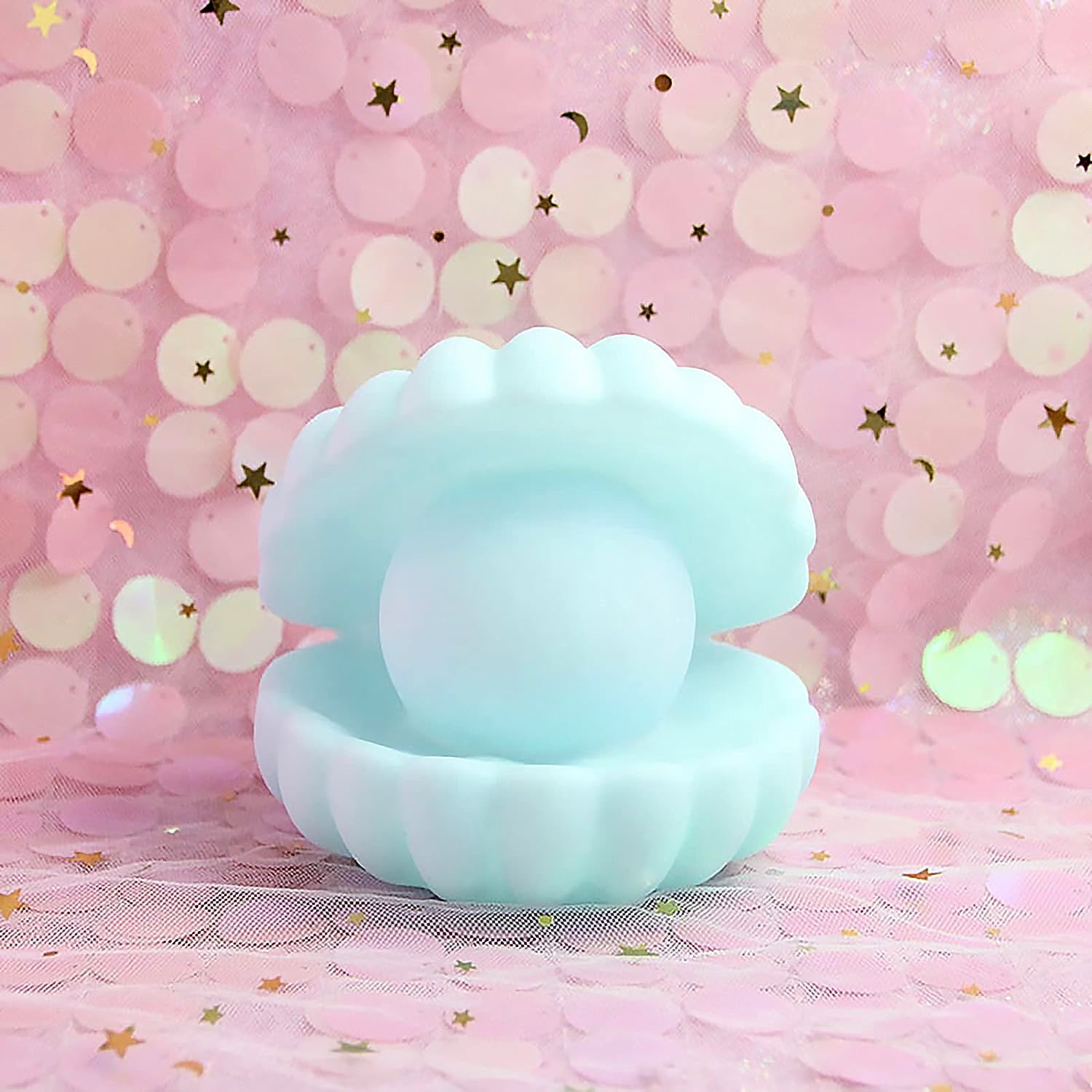 A hand holding the compact Pearl Shell Night Lamp, demonstrating its portable size.