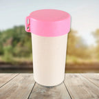 Portable coffee mug enjoying an outdoor setting, ideal for picnics or camping trips.