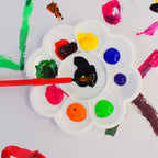 Kid using bright watercolour paints from the artistic water colour kit set