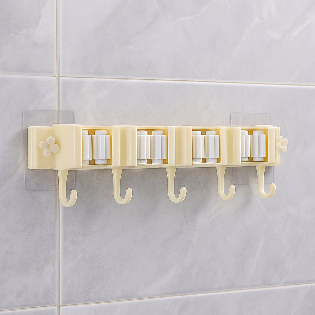 Self-adhesive broom and mop holder rack mounted on wall with utility hooks