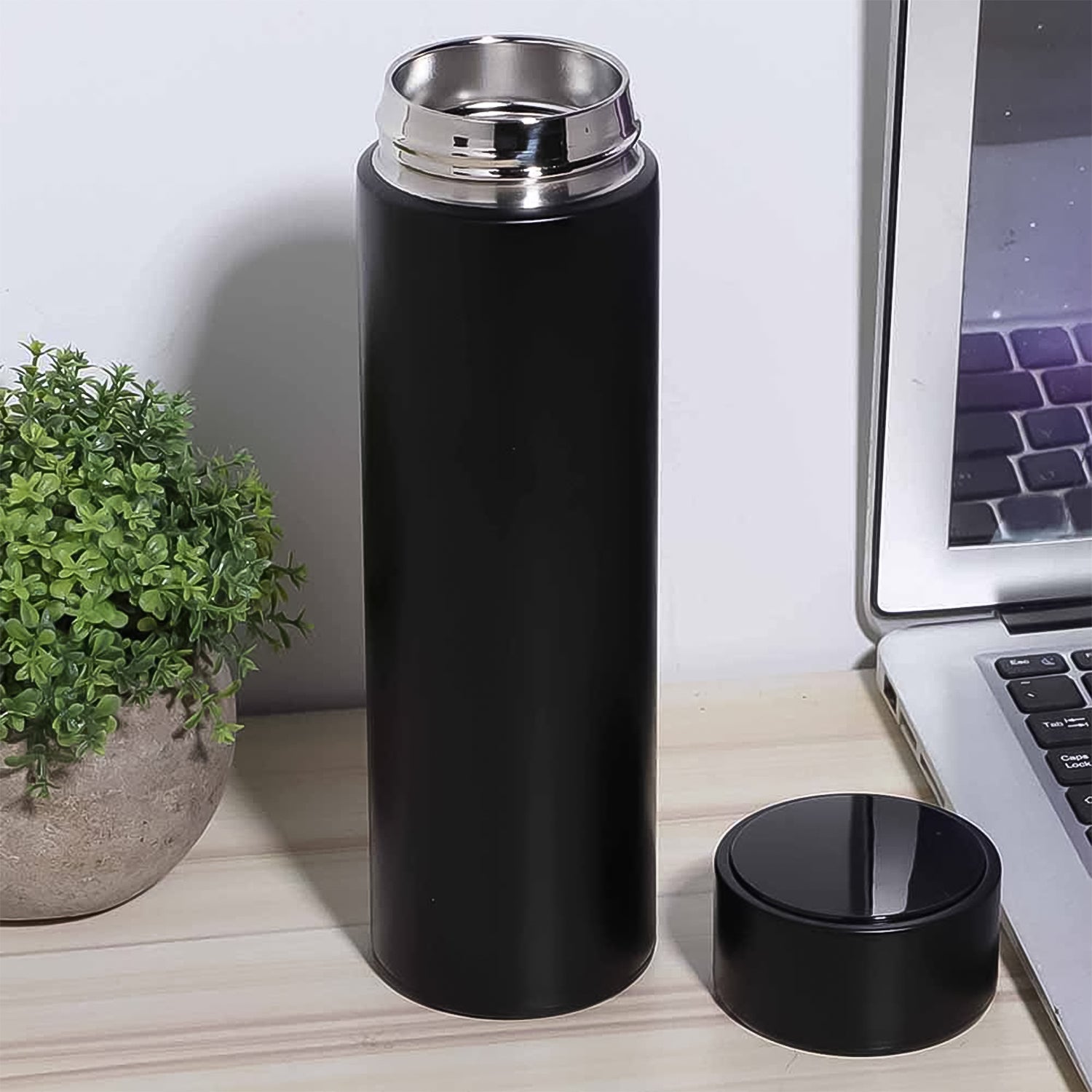 Person holding the sleek 500ml insulated water bottle, ideal for travel.