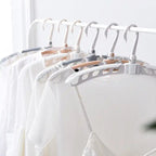 Adjustable arms of the folding clothes hanger demonstrated.