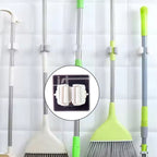 Single adhesive mop holder securely holding a mop on a wall.
