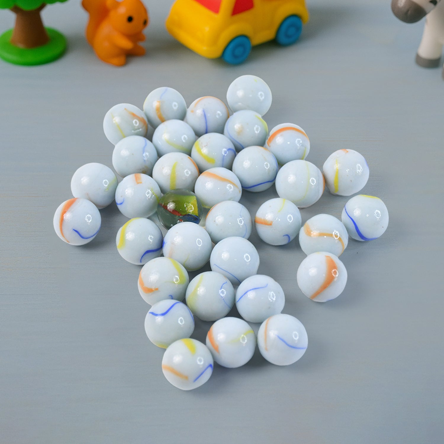 Closeup of polished white glass marbles featuring colorful swirl details