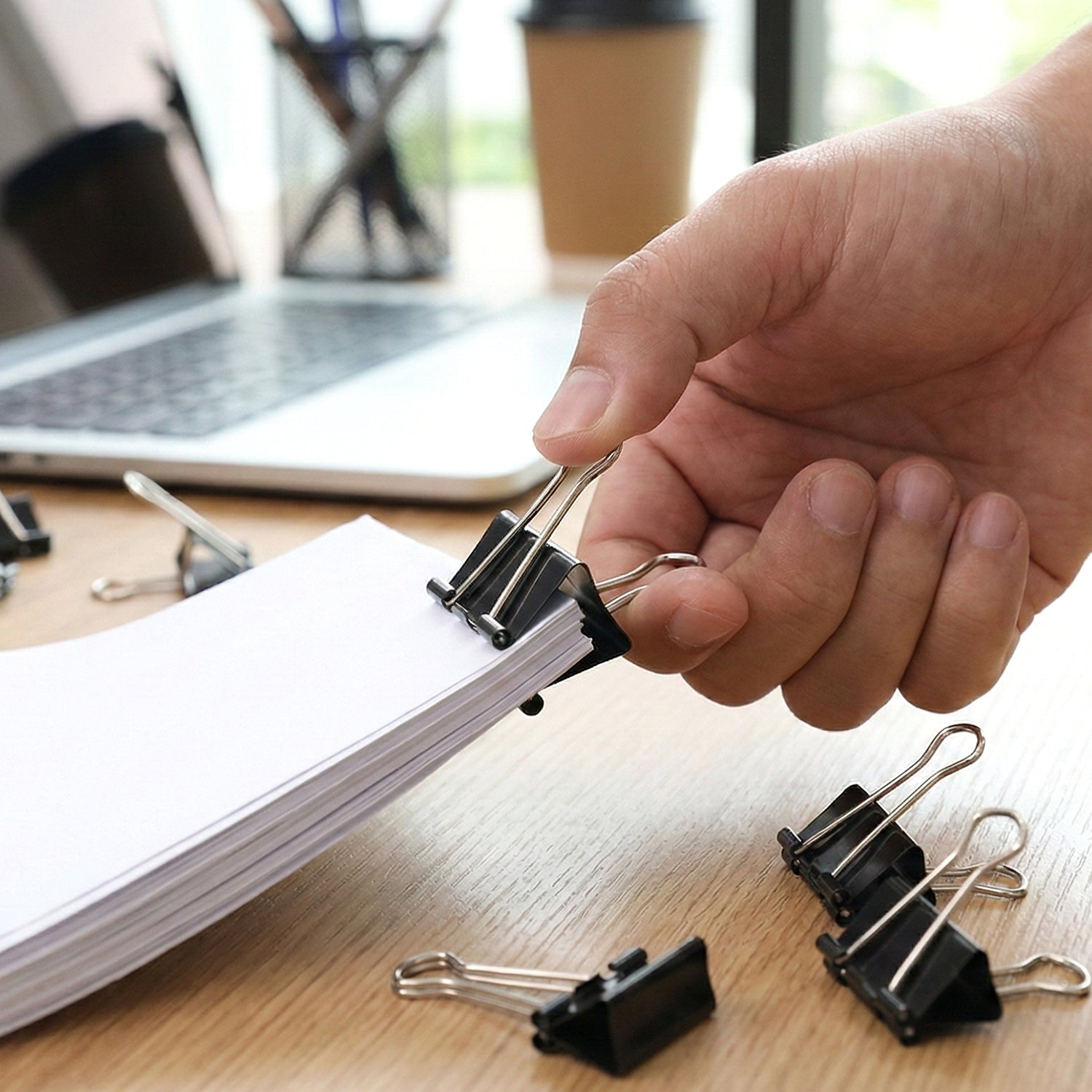 Black metal binder clips securing paper stacks