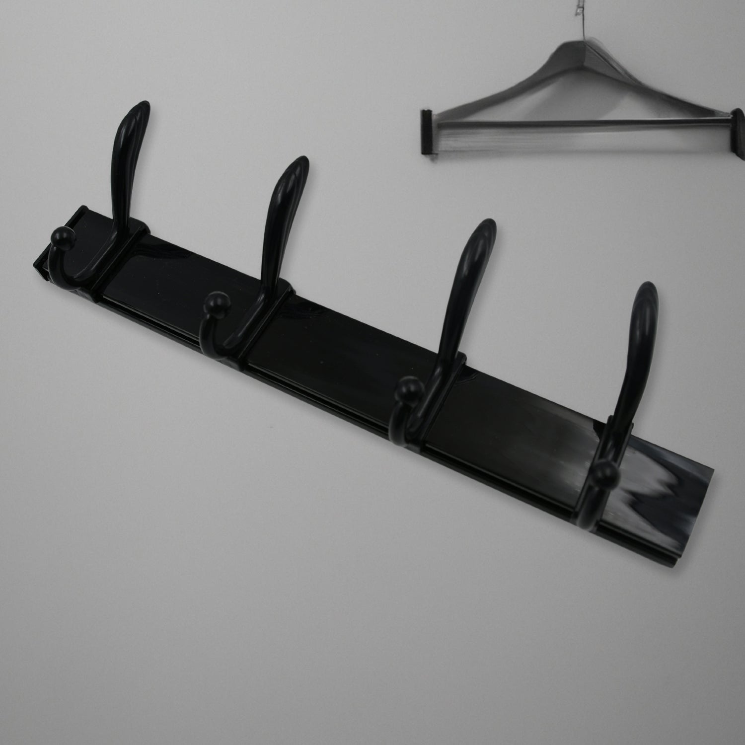 Top-down view of the 4-hook wall mount coat hanger holding various coats and hats.