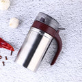 Sleek stainless steel oil dispenser with a small pouring nozzle on a white background.