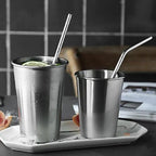 A sleek stainless steel straw elegantly placed next to a refreshing beverage.