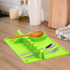 Heat-resistant silicone spoon rest preventing drips on a kitchen counter.