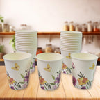 Disposable paper cups in mixed colours and designs, ready for use.