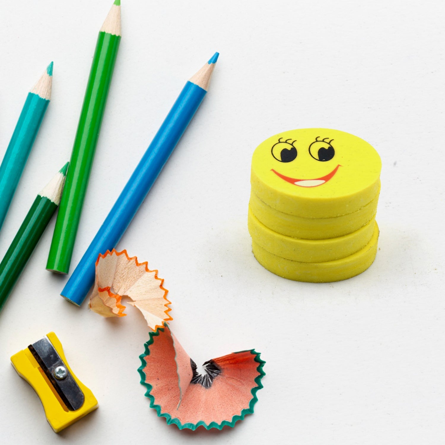Four vibrant smiley emoji erasers, perfect for kids' school supplies.