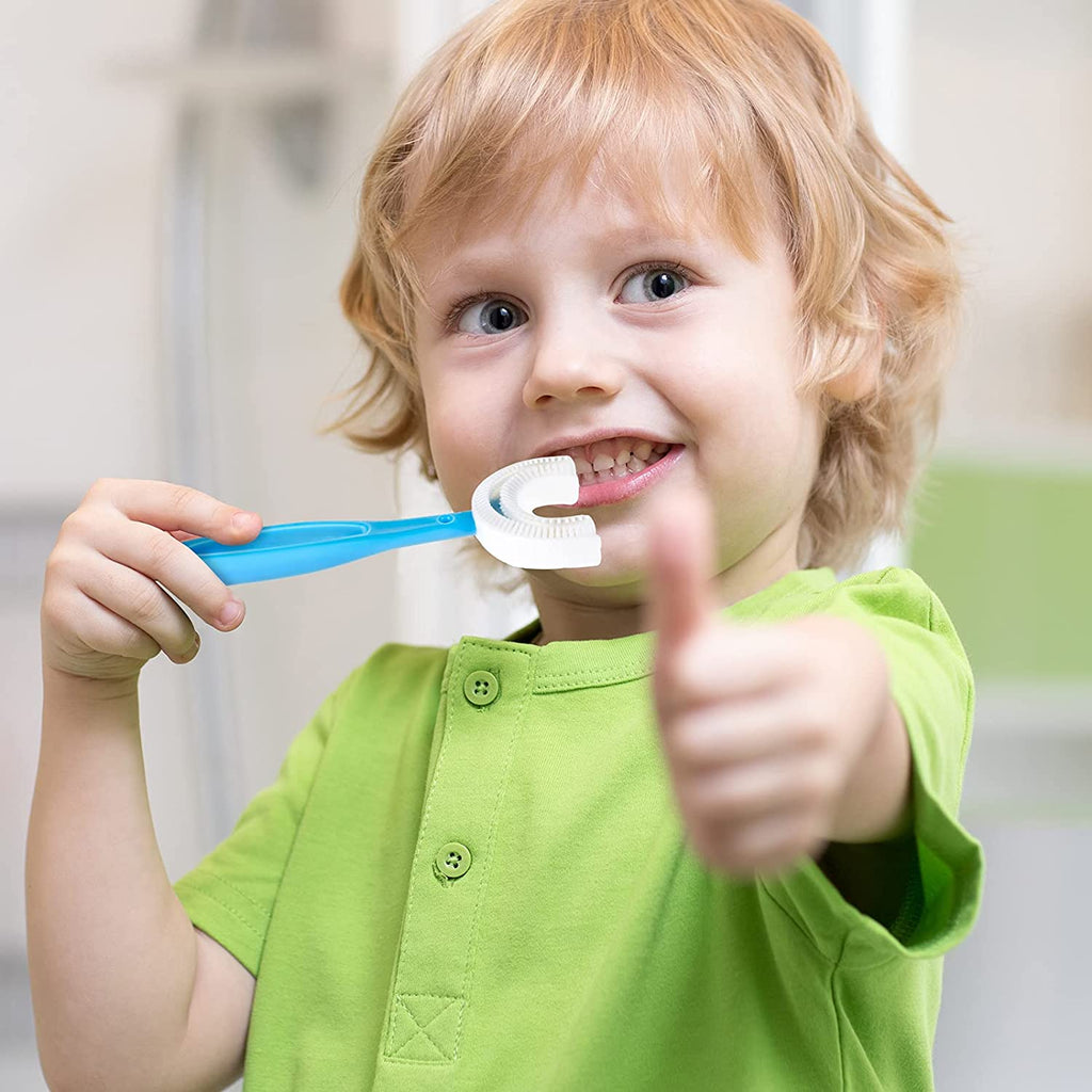 Child holding a green Kids U-Shaped Toothbrush, demonstrating easy use.