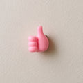 Pink hand-shaped wall clip holder made of silicone on white background