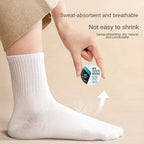 A pair of compact, white disposable travel socks for easy packing.