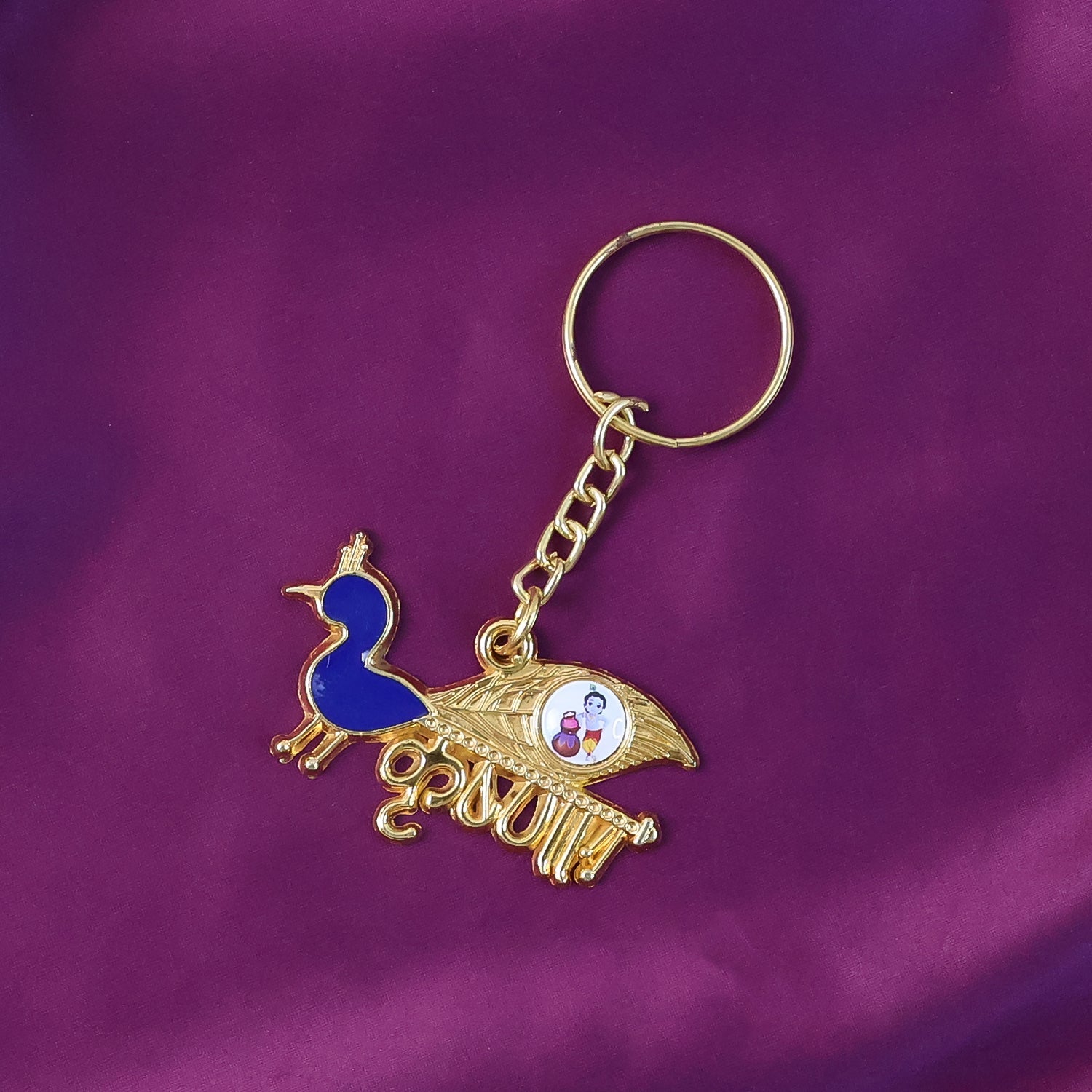 Gold-tone Krishna metal keychain displayed on white background