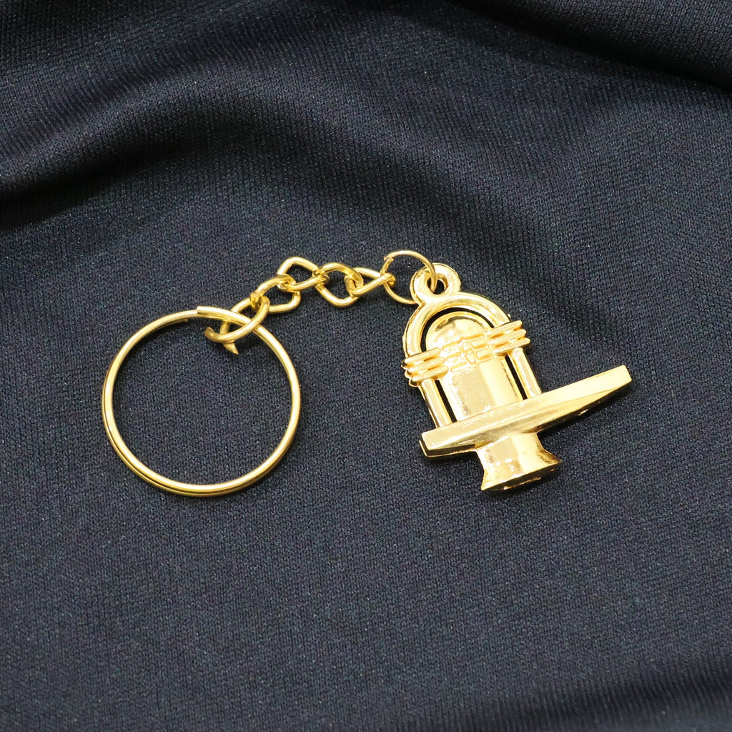 Golden Shivling metal keychain showcased alongside measuring scale revealing size