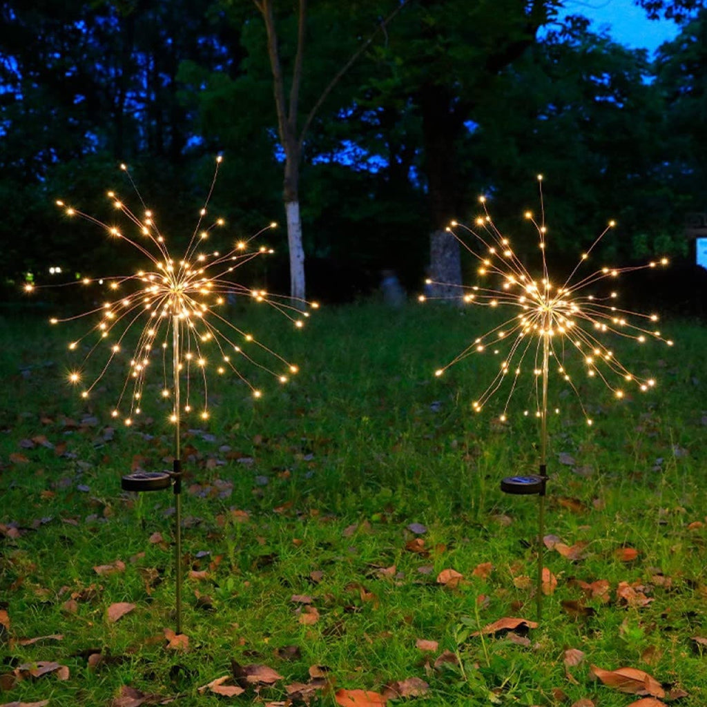 Solar powered warm white starburst garden light illuminating outdoor pathway