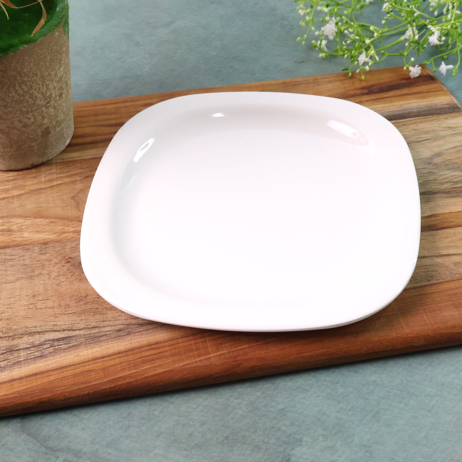 White square plastic dinner plate with rounded edges and glossy surface