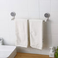 Self-adhesive towel rod mounted securely in a bathroom holding towels