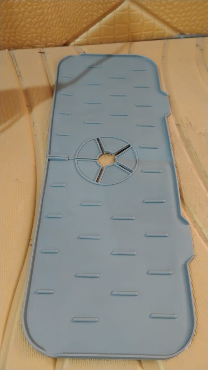Detailed view of the sloped grooves on the silicone faucet mat, designed for efficient water drainage.
