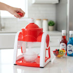 Kitchen ice shaver machine producing fine snow ice into a serving bowl.