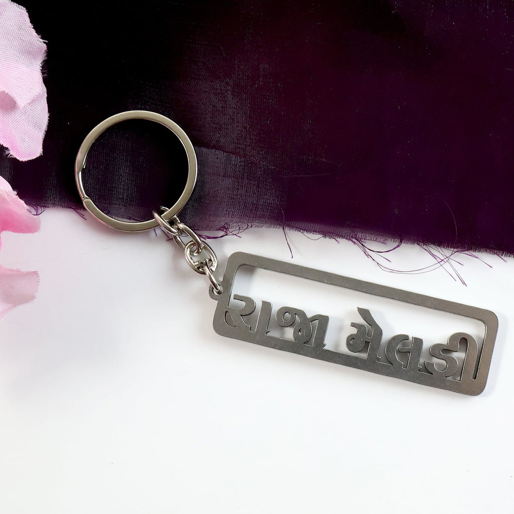 Premium metal keychain showcasing cutwork Gujarati lettering
