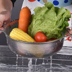 Stainless steel colander with ergonomic handle, viewed from above, showcasing fine mesh.