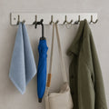 Stainless steel coat rack with 6 hooks mounted on the wall for hanging
