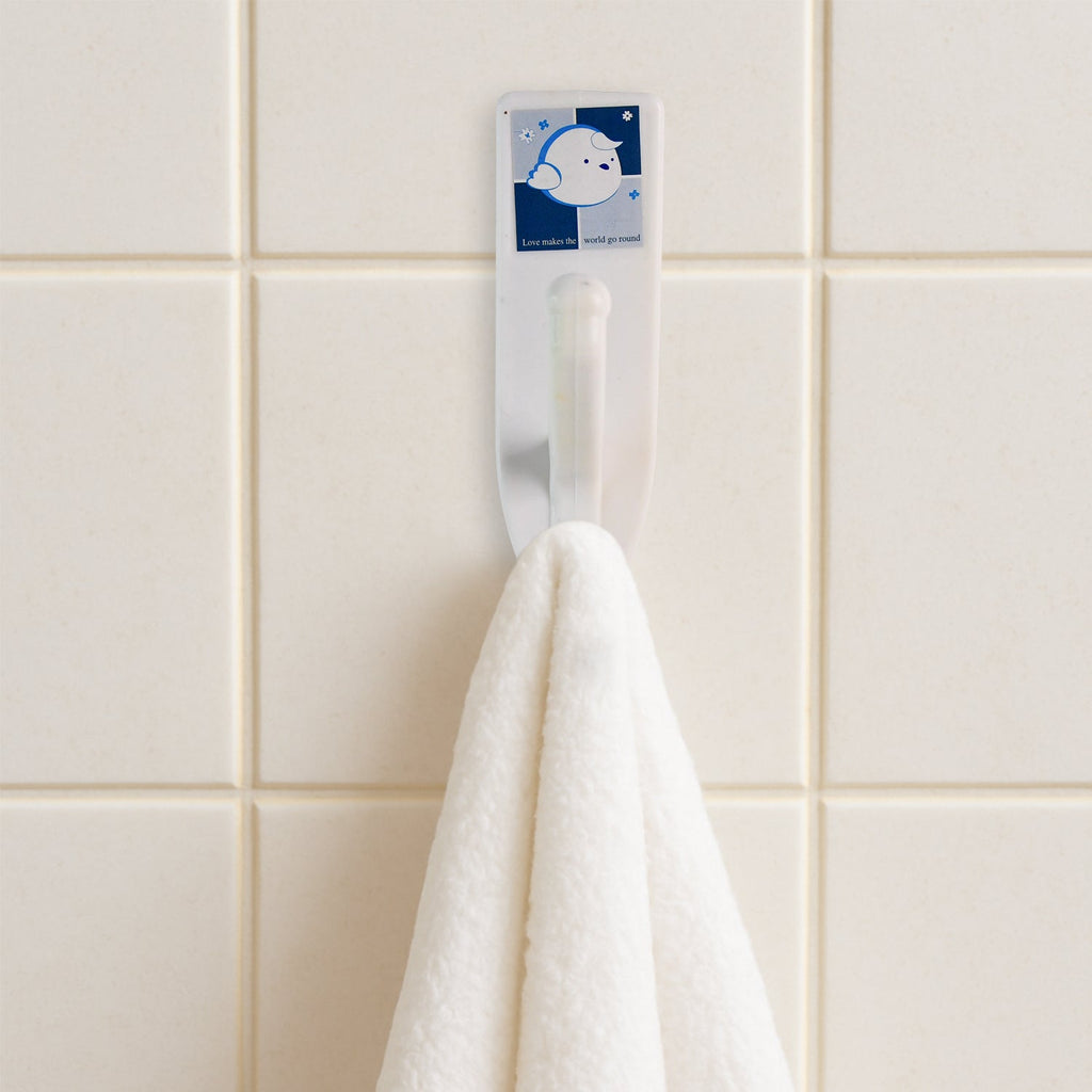 Stylish self-adhesive wall hooks mounted on a kitchen wall, organizing utensils.