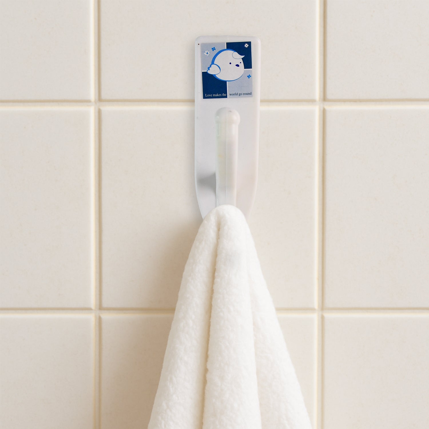 Stylish self-adhesive wall hooks mounted on a kitchen wall, organizing utensils.