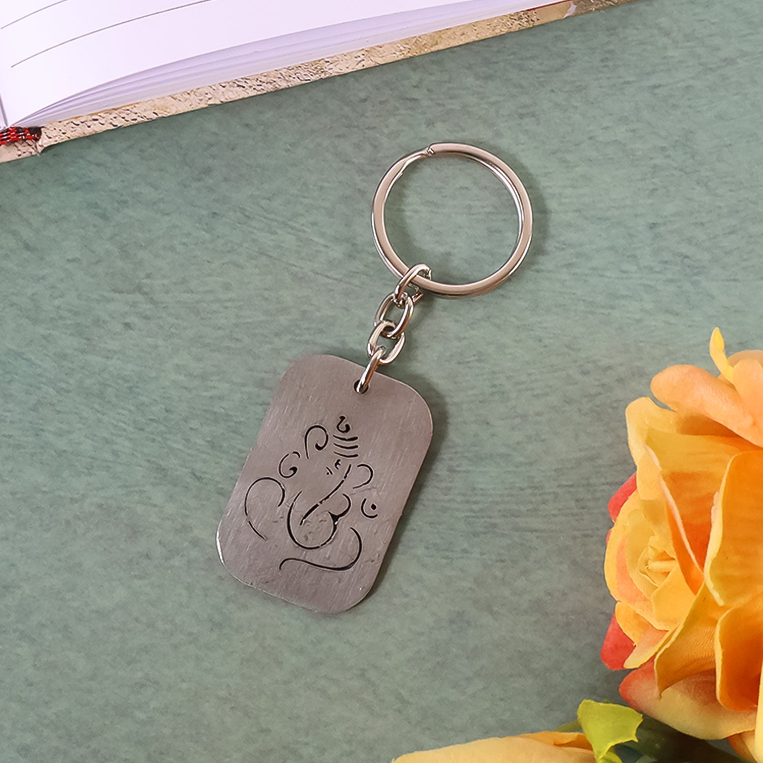Detailed view of the Ganesh cut-out on the metal keychain, highlighting its fine craftsmanship.