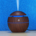 Compact USB desktop humidifier with multi-color LED lights on a clean surface.