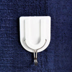 A small adhesive hook in a hallway, perfect for hanging keys and other small items.