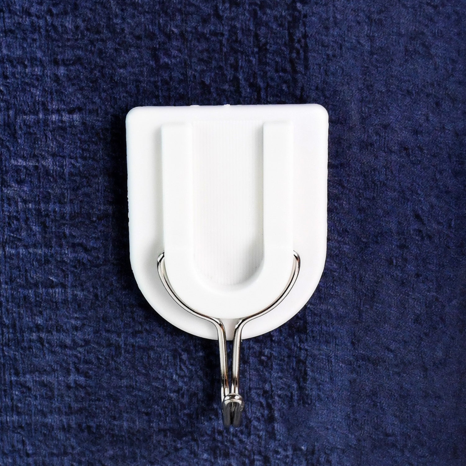 A small adhesive hook in a hallway, perfect for hanging keys and other small items.
