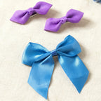 Side angle showing satin ribbon bow hair clips for girls