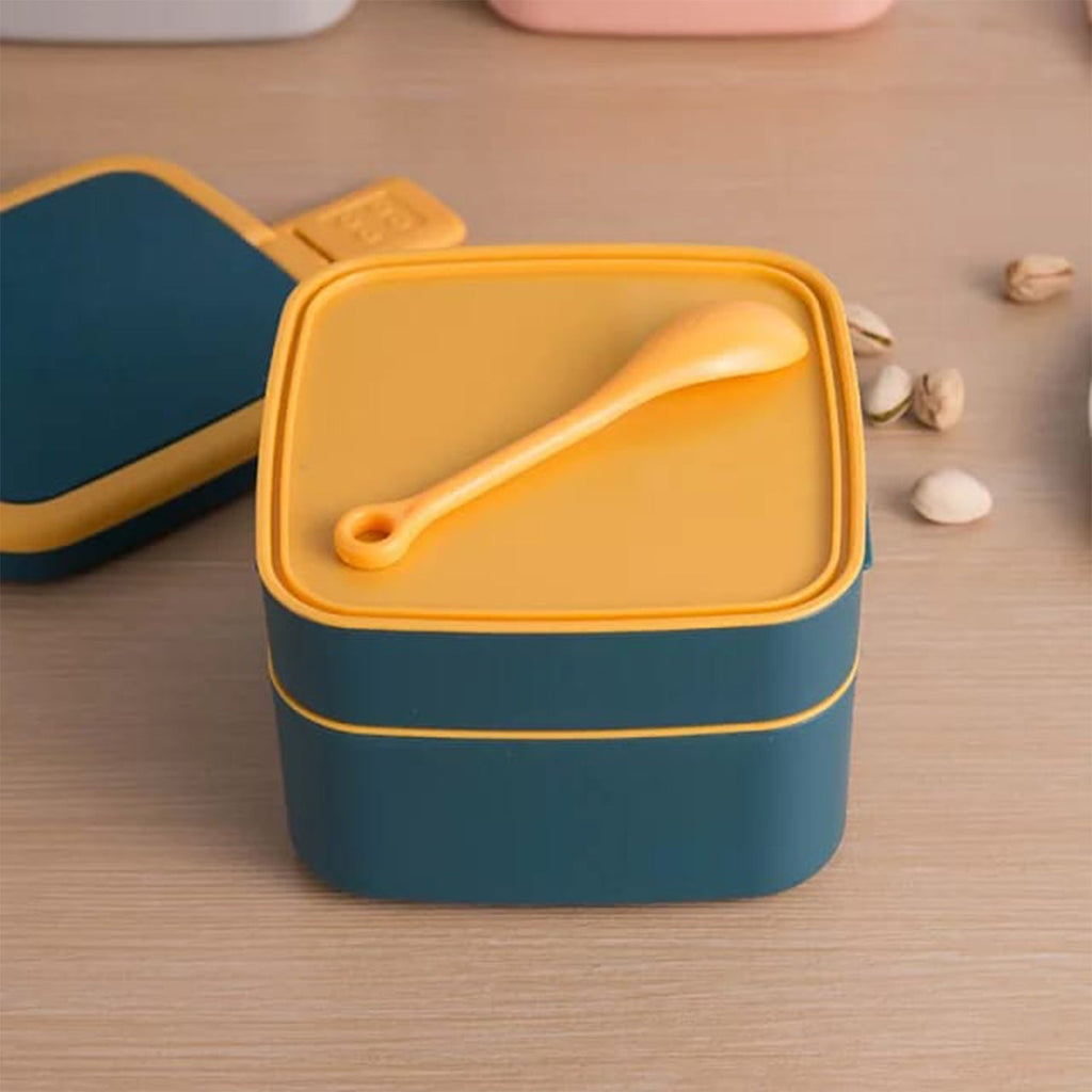 Vibrant blue double-layer bento lunch box with an integrated handle and spoon.