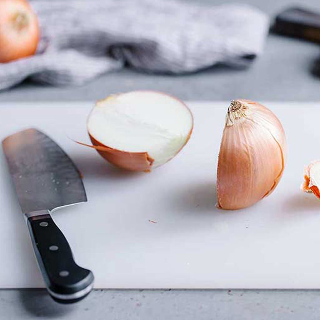 Sturdy plastic chopping board, ideal for daily food preparation in Indian kitchens.