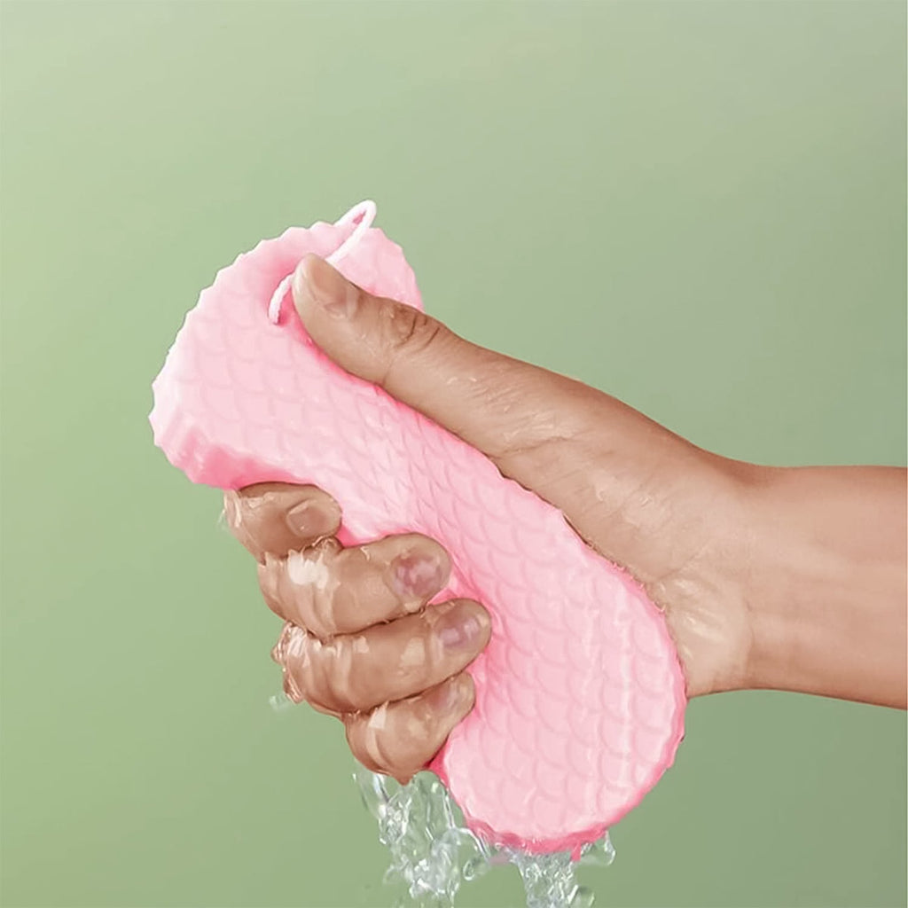 Person gently using the exfoliating sponge on their arm for smooth skin.