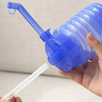 Hand pressing the manual drinking water pump to dispense water from a bottle.