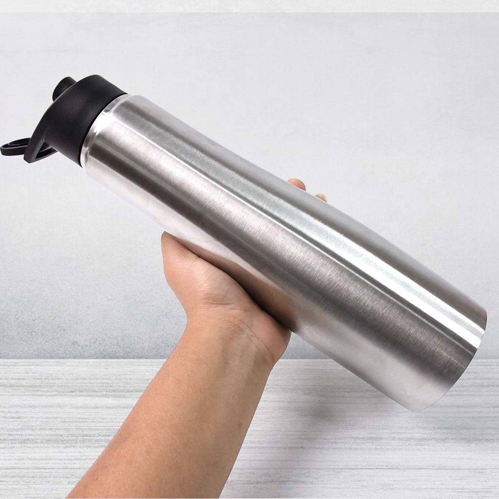 Reusable stainless steel water bottle held in hand for daily use